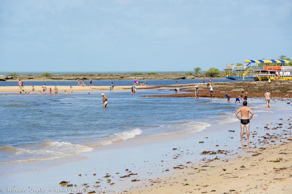 Imagem de vários turistas se deliciando nas águas da Praia de Santo André.